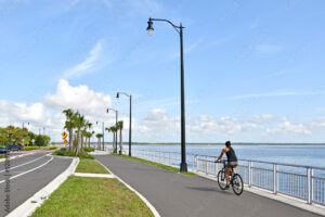 Image of a woman riding a bike in a tropical setting